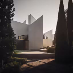the white exterior of a building with trees in front