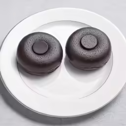 two cookies on a plate that are black