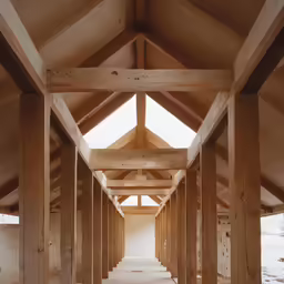 an unfinished hallway is featured with columns and beams