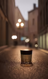 a small cup sitting on the ground near an alley way