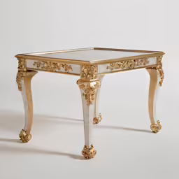 a gold and white small square table that has an elaborately carved edge