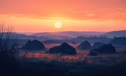 the sun is setting over rocks in the field