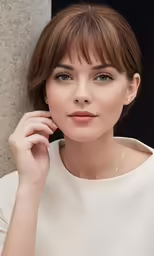the woman in the white dress has short hair and a large diamond necklace