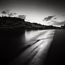 a dark and gloomy beach with some low flying clouds