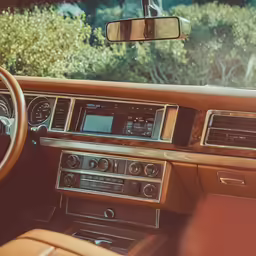 the interior of a brown luxury car with dashboard controls