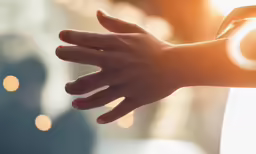 an hand with one extended arm reaches out toward something and is glowing