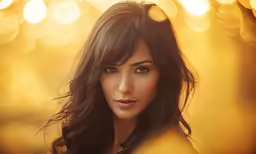 a woman is looking into the camera with a blurry background