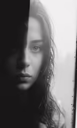 a black and white photo of a woman with water droplets all over her face