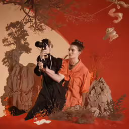 a man taking a photo with a woman behind him