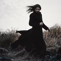 an old woman walking alone in the grass