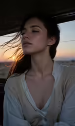a woman sitting in the passenger seat of a car, looking out a window at the setting sun
