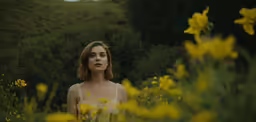 a woman standing in a flower filled field