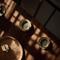 the shadow of bowls and plates on a table