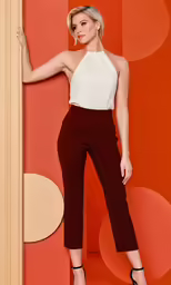 a woman standing next to a doorway in black pants