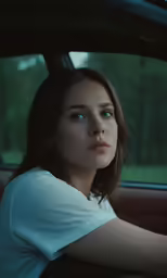 a woman sitting in a car driving the road