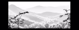 black and white photo of snowy mountains on cloudy day