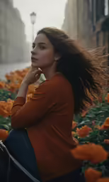 the young woman is sitting on a bench in a flower garden