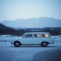 an old station wagon is parked in a snowy landscape