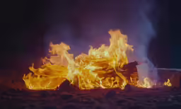 a bright bonfire is lit at night with bright flames