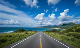 a very long road going into a beautiful blue ocean