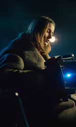 a woman with a hooded jacket and camera with light coming from the lens