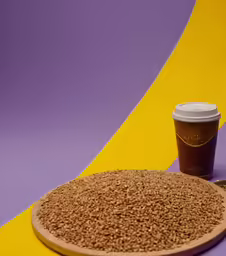 a coffee cup is placed next to a tray of food