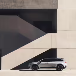 a compact suv parked in front of a very modern building