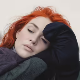 the young woman has her face close to her arm