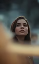 a woman with dark hair looking down while standing outside