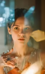 a woman looks at herself as she stands in front of a glass