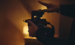 someone holding a camera on a tripod looking down
