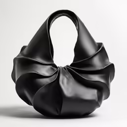 black leather bag with a twisted handle on the shoulder