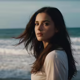 a young woman is standing near the water