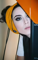 a woman wearing earbuds and a yellow hat