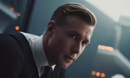 a man looks at the camera while sitting down