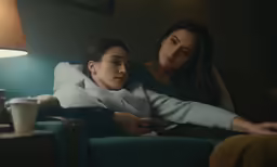 the woman is laying down next to the young lady