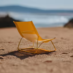 a chair is on the sand near the water