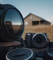 a camera is pictured with multiple lenses sitting around it