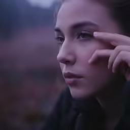 a beautiful young woman is staring into the distance