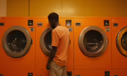 a man stands in front of two washing machines