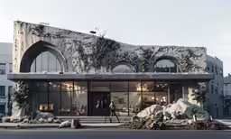 a person walks by a building with a green and black architecture