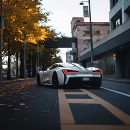 a white sports car on the road next to tall buildings