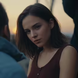 a girl in red sits against a man looking away