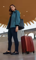 the young woman is standing by her luggage