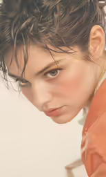 an adult female with brown hair and short frecking looks at the camera