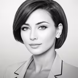 a woman with a short black hair in a grey jacket and diamond earrings