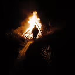 a man walking away from a blazing fence
