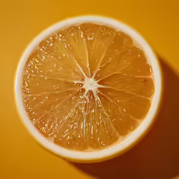 orange sliced in half with the background bright yellow