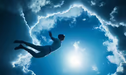 a man jumping in the air in front of a cloudy sky