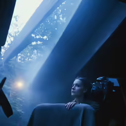 an adult is holding her hand up behind a large camera